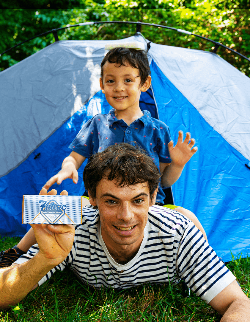Max & Arlen holding a bar of fabric waterproofing with a tent.